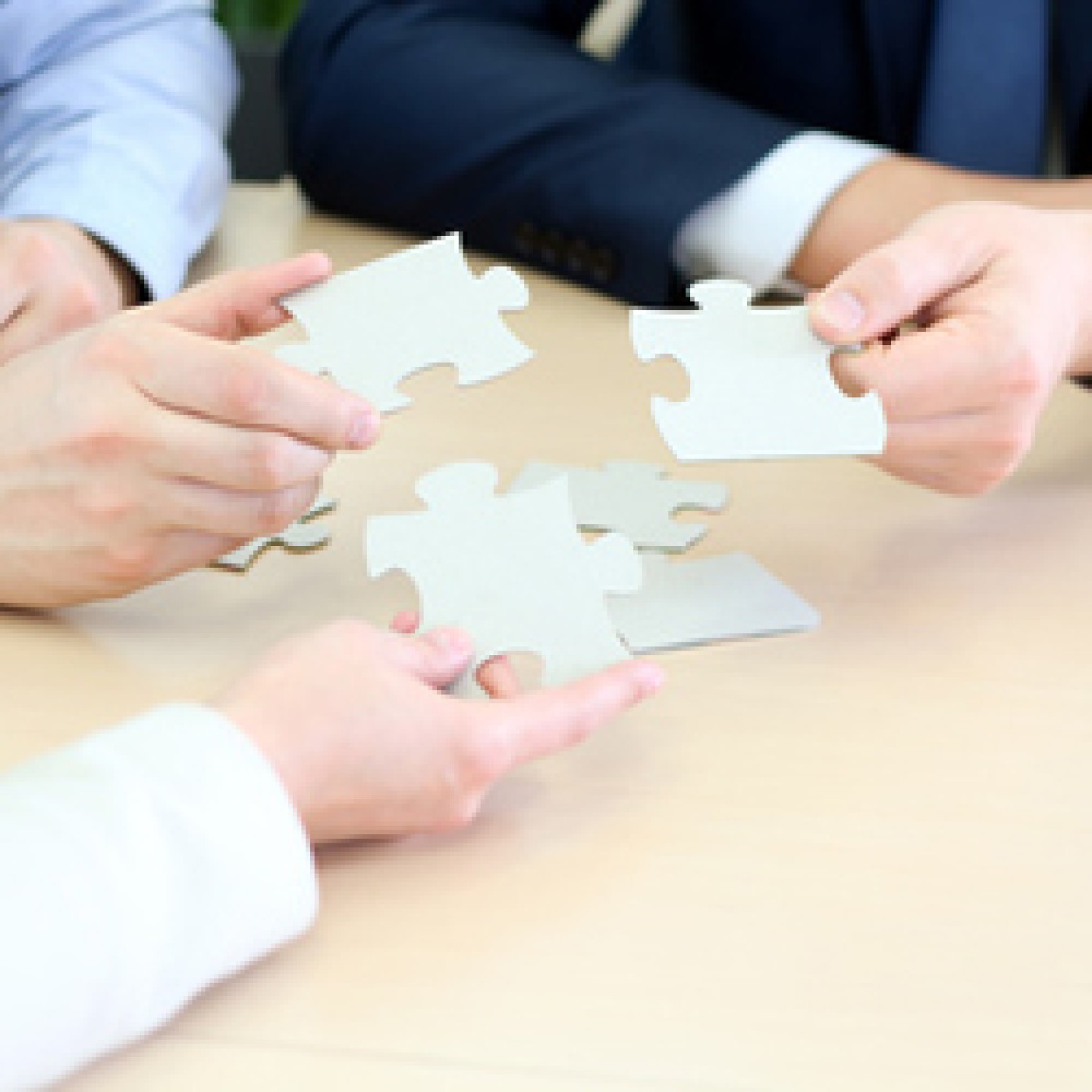 Close-up Of Businessmen Hand Connecting Jigsaw Puzzle